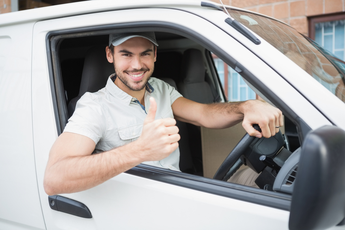 Delivery driver showing thumbs up driving his van